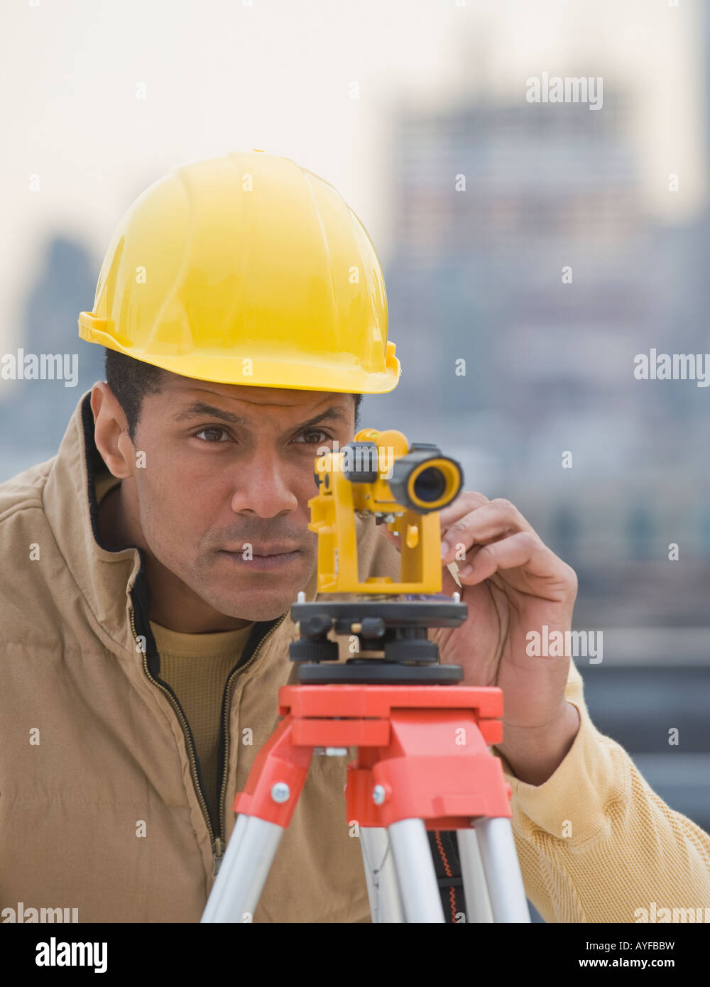 African male surveyor looking through measuring device Stock Photo Alamy