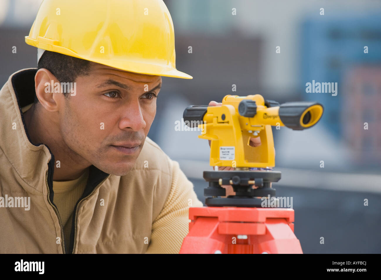 African male surveyor looking through measuring device Stock Photo Alamy