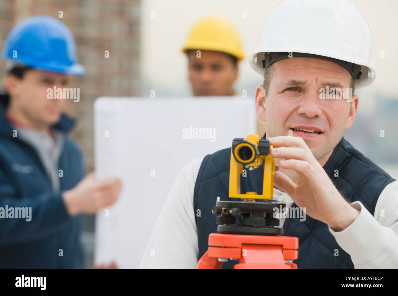 Male surveyor looking through measuring device Stock Photo Alamy