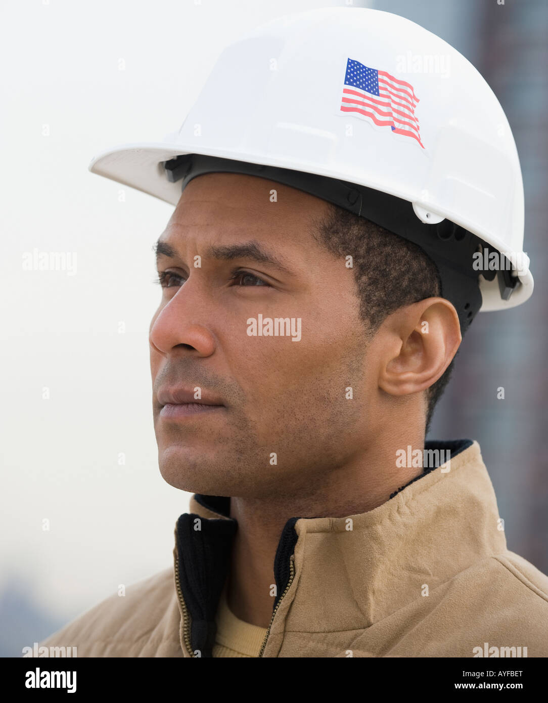 African male construction worker with American flag on hard hat Stock Photo