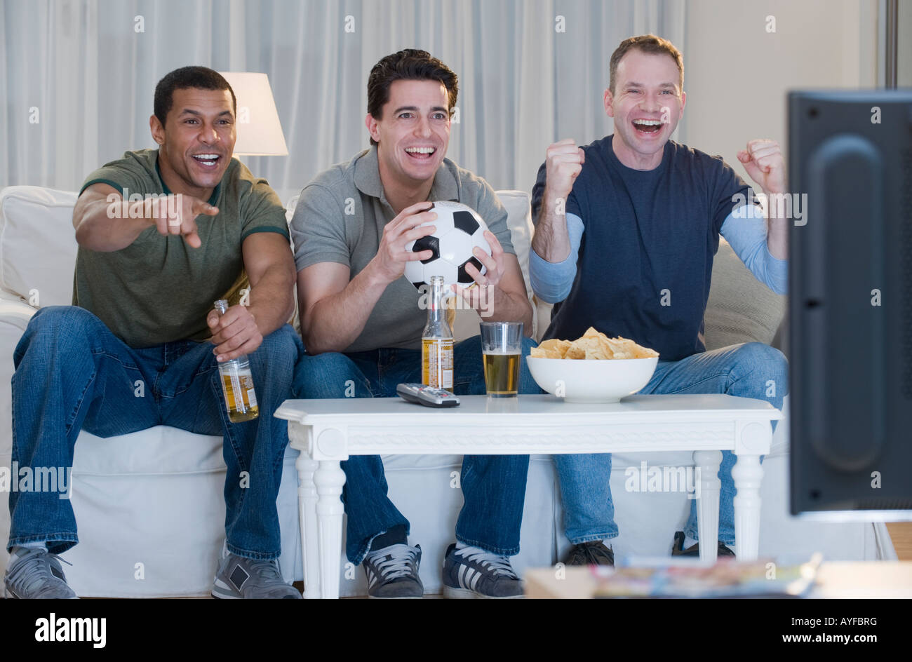 Multiethnic men watching sports on television Stock Photo Alamy
