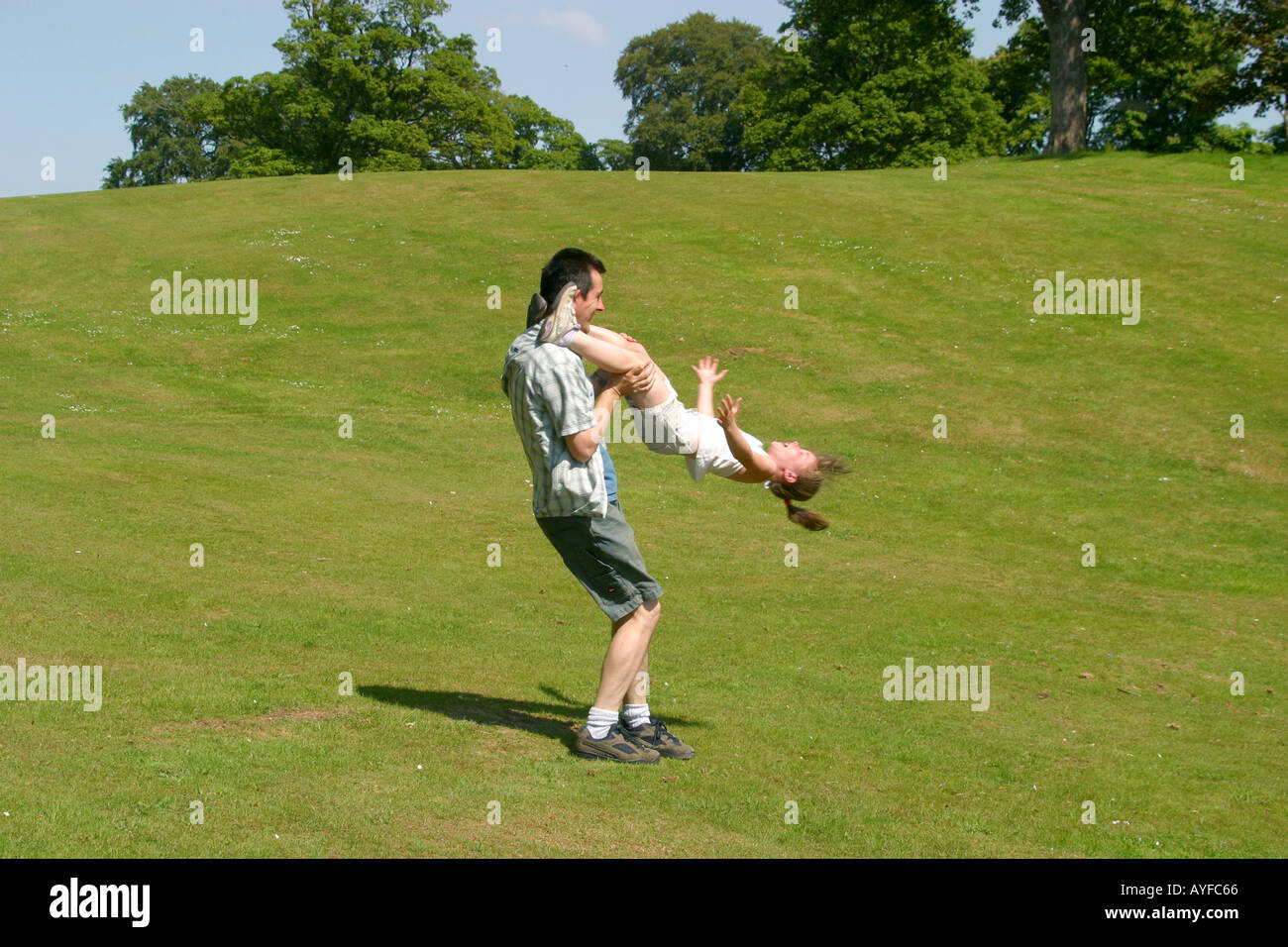 Father spinning young daughter around by her legs Stock Photo