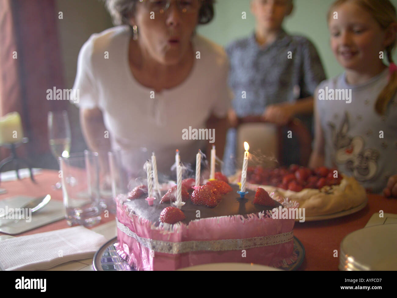 Blowing out candles on a birthday cake Stock Photo - Alamy