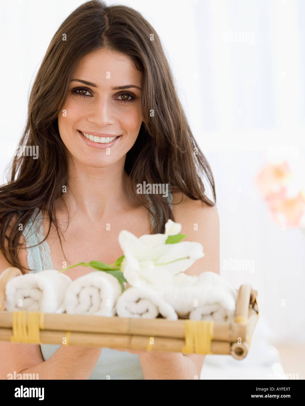Woman holding tray of rolled towels Stock Photo - Alamy