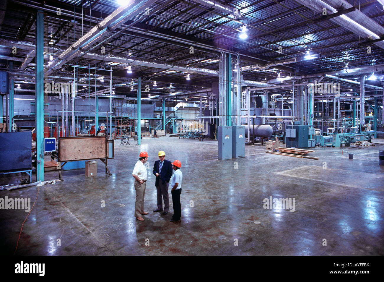 Engineers confer in new manufacturing facility Stock Photo