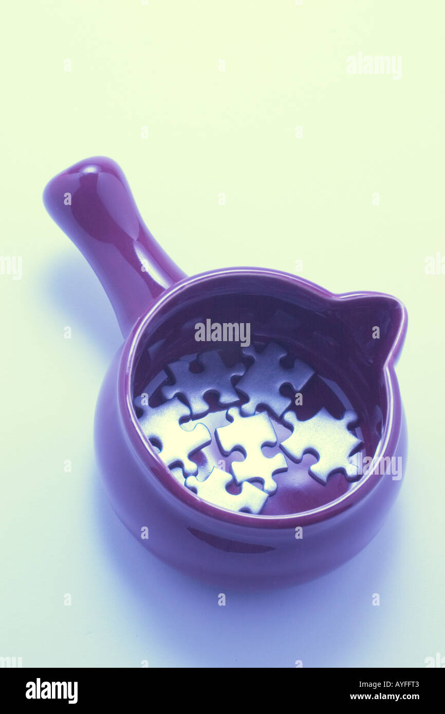 Jigsaw Puzzle Pieces in Saucepan Stock Photo