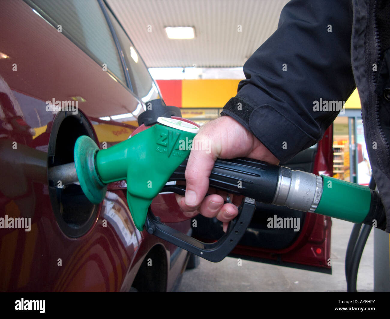Putting unleaded petrol into a car filling up with fuel close up of a
