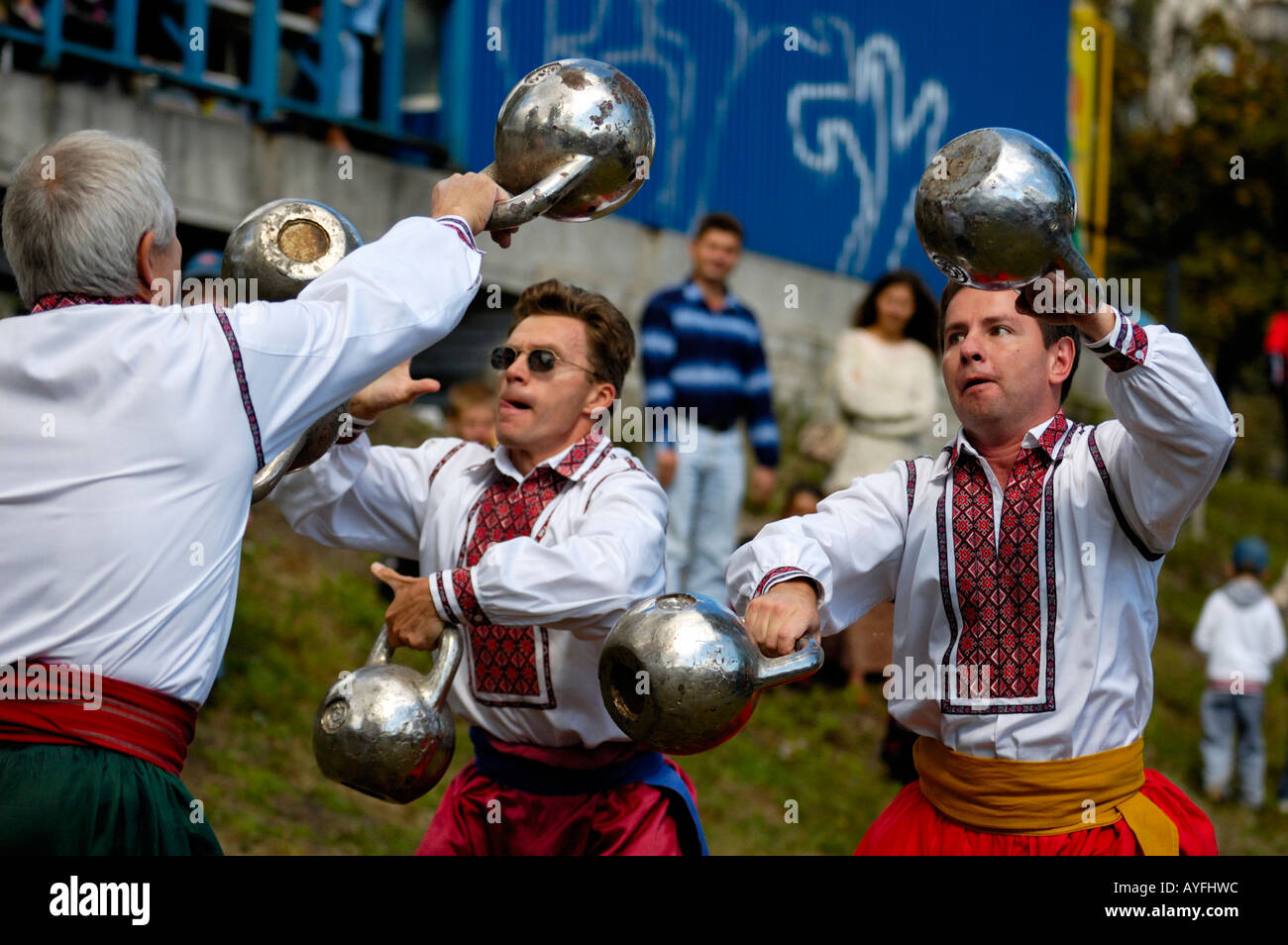 Four men juggling with dumb bells Stock Photo