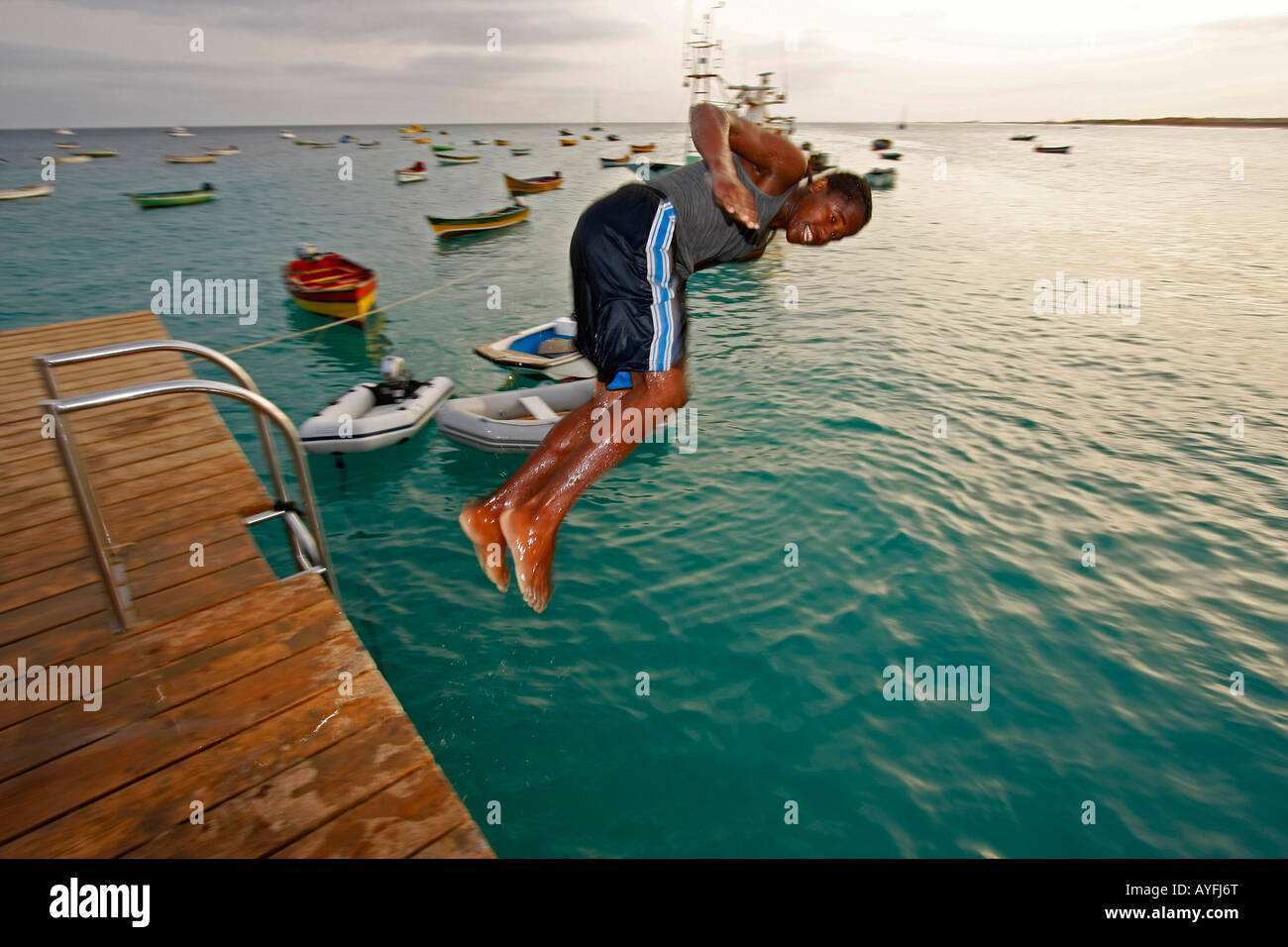 boy jumping into the sea from the pier in Santa Maria - Sal island Cape Verde Africa Stock Photo