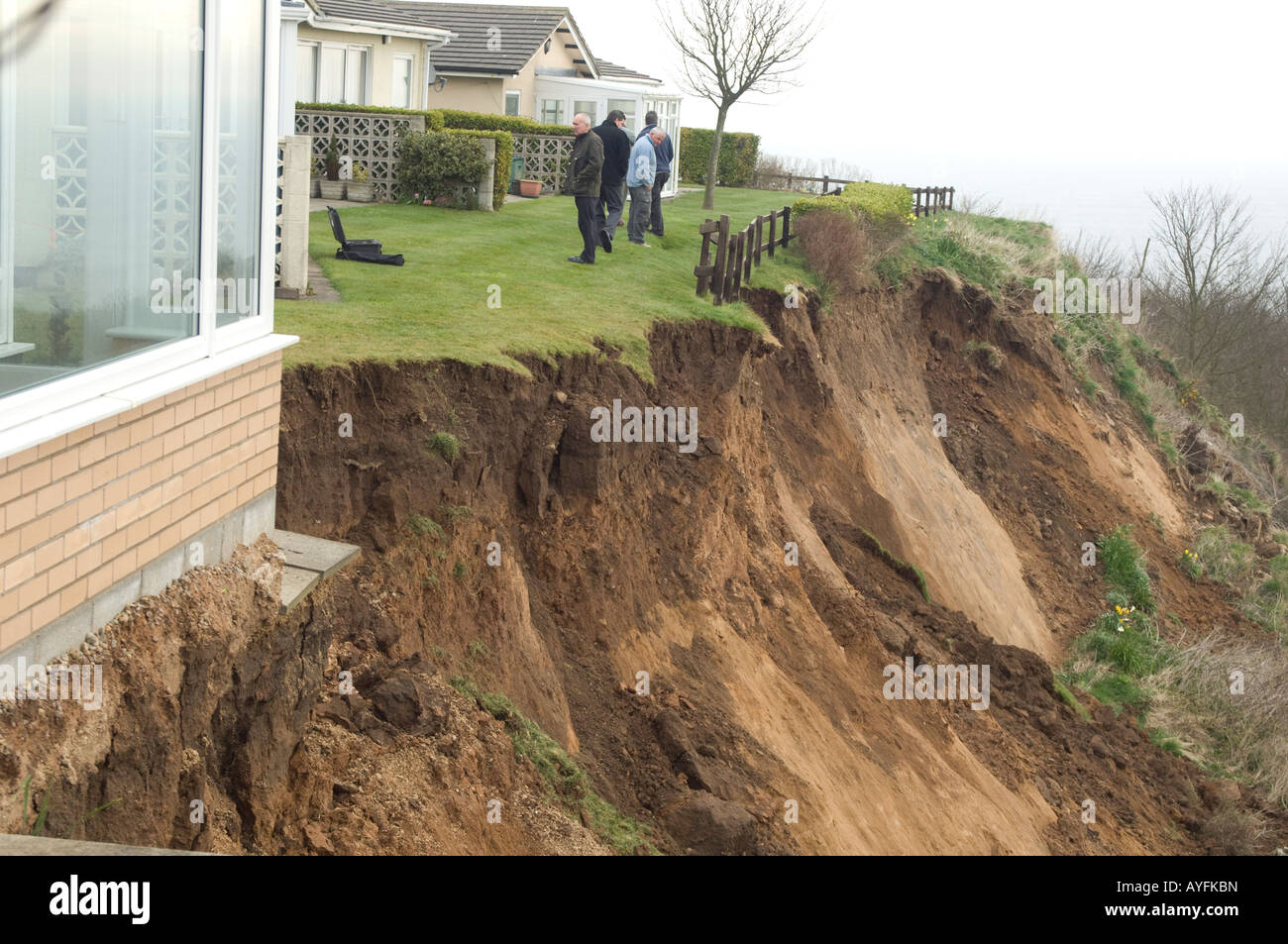 Residents in garden by cliff landslide at Knipe Point, Yorkshire, UK
