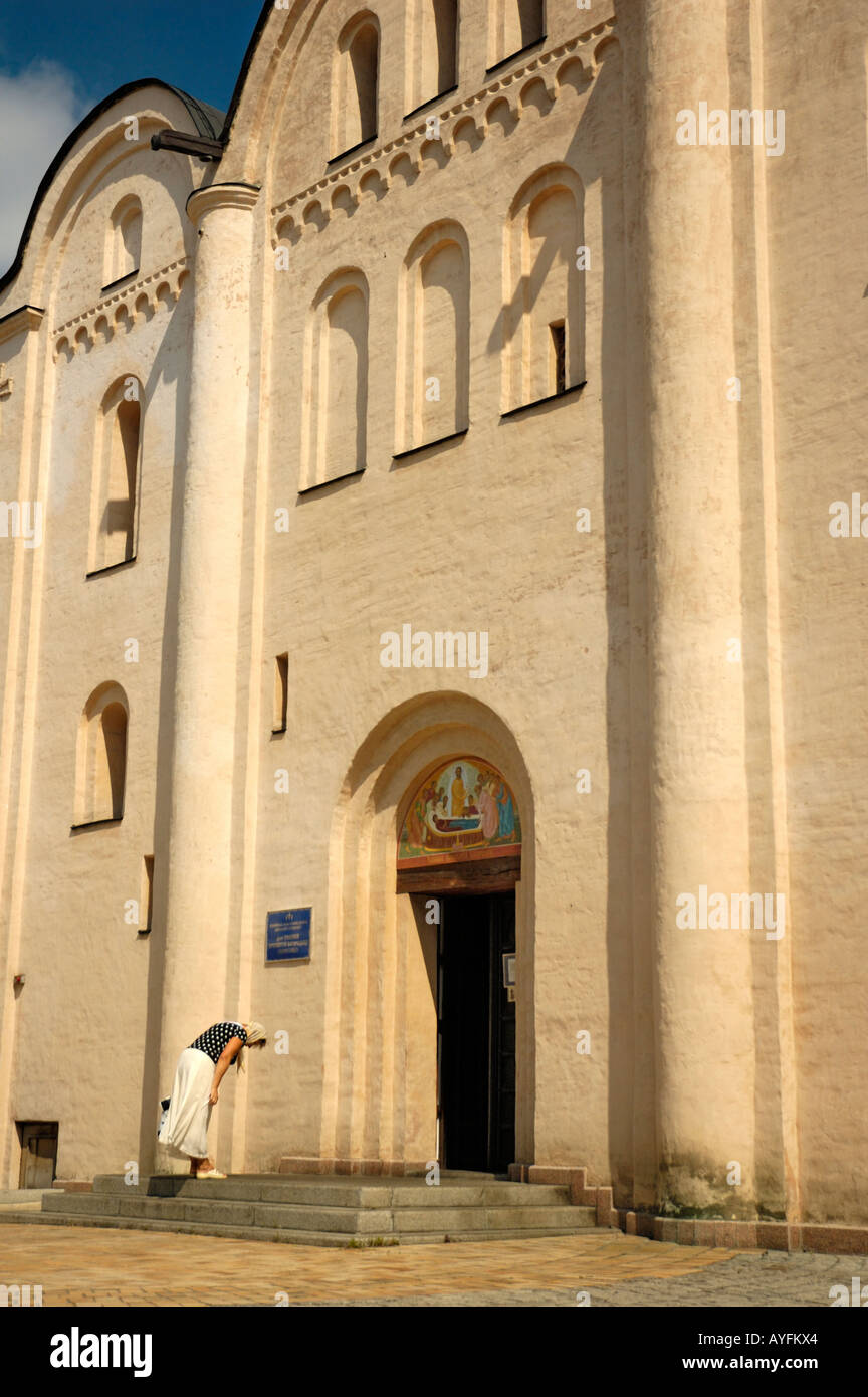 Woman bowing before entering to the church Stock Photo