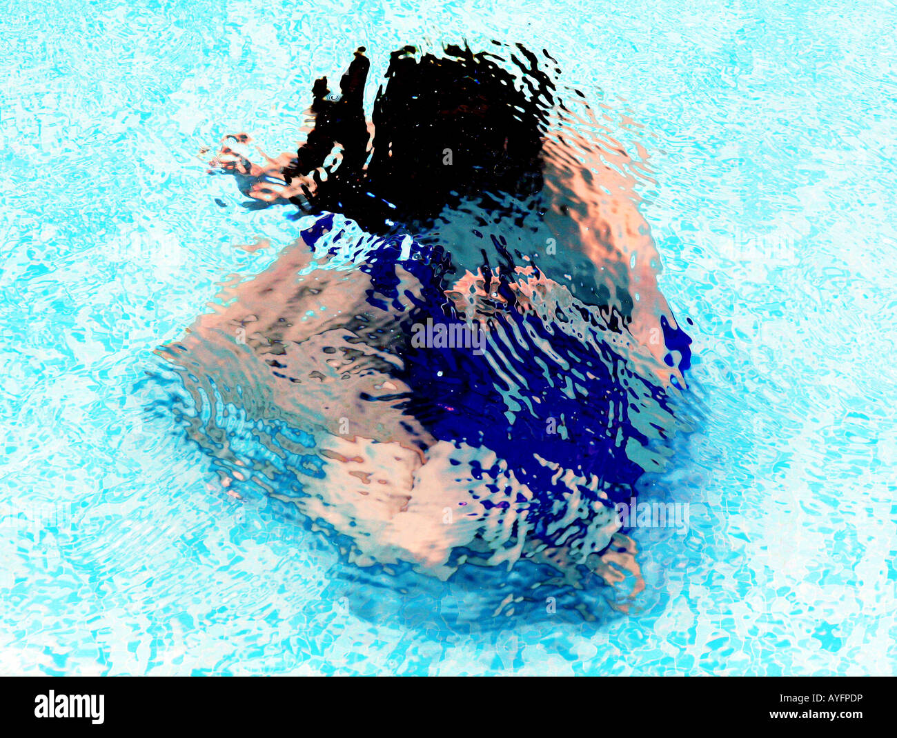 Young boy floating in swimming pool Stock Photo