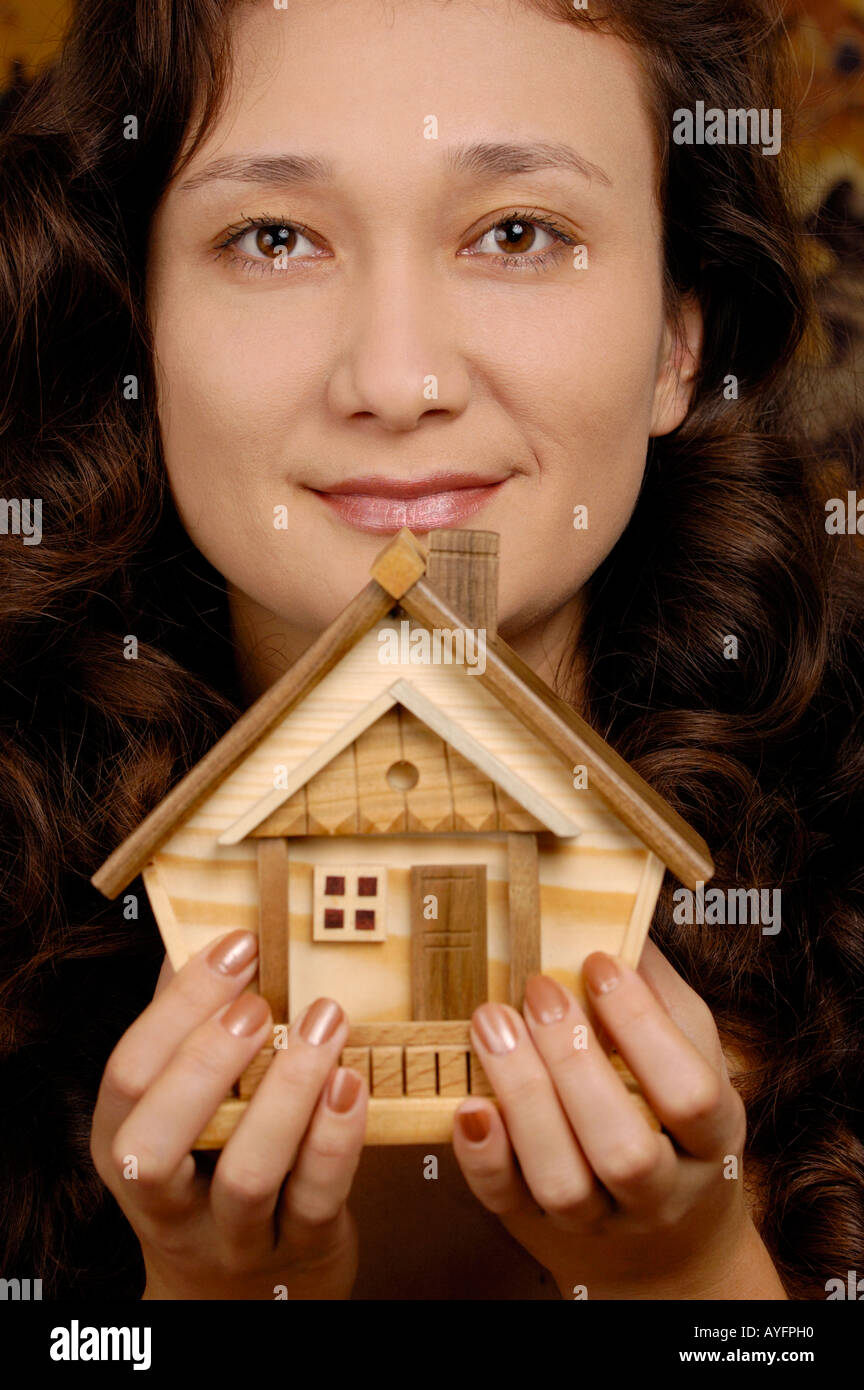 Woman holding a small wooden house in her hands Real estate housing ...