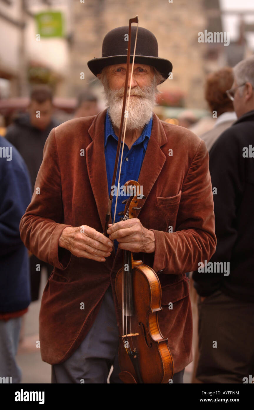 A MUSICIAN PLAYS A FIDDLE AT THE FARMERS MARKET IN STROUD GLOUCESTERSHIRE UK Stock Photo