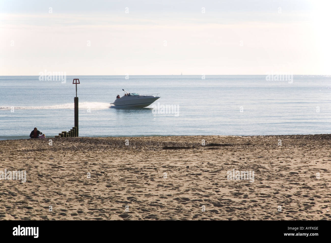 A motor boat speeds close the Southbourne shore on a calm day Stock Photo