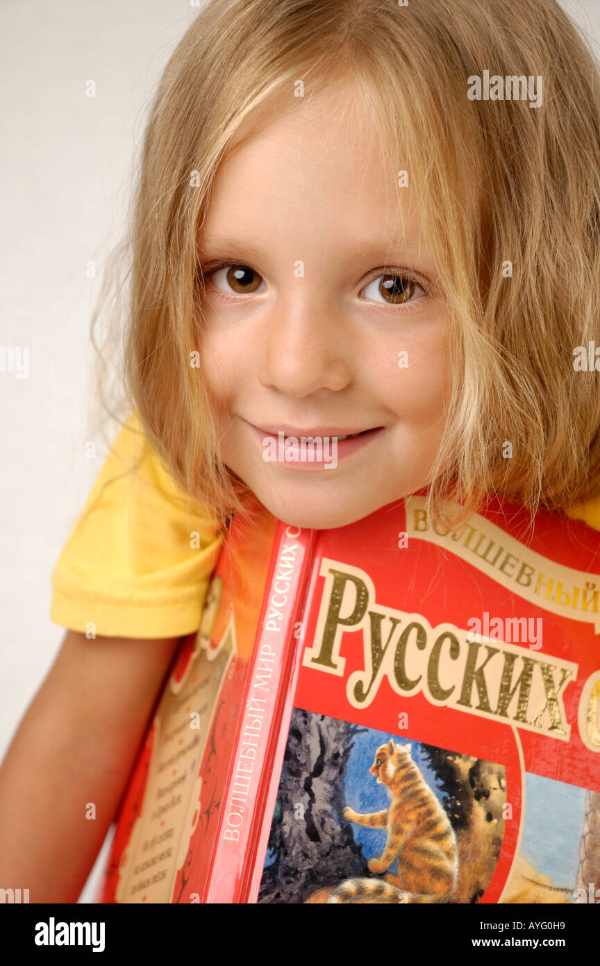 Cute little girl with a big book Stock Photo - Alamy