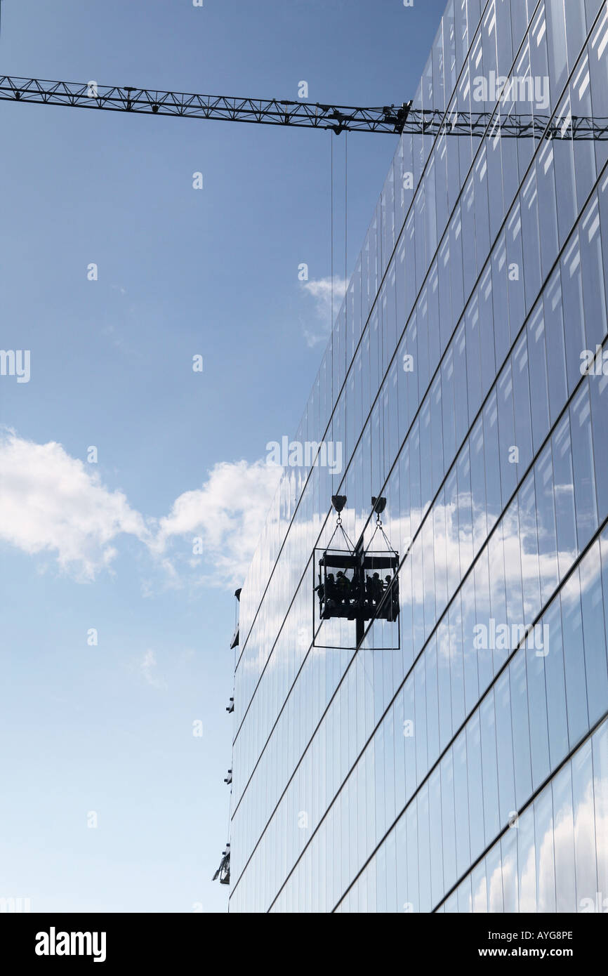 window cleaners on the outside of a large glass office building in london Stock Photo
