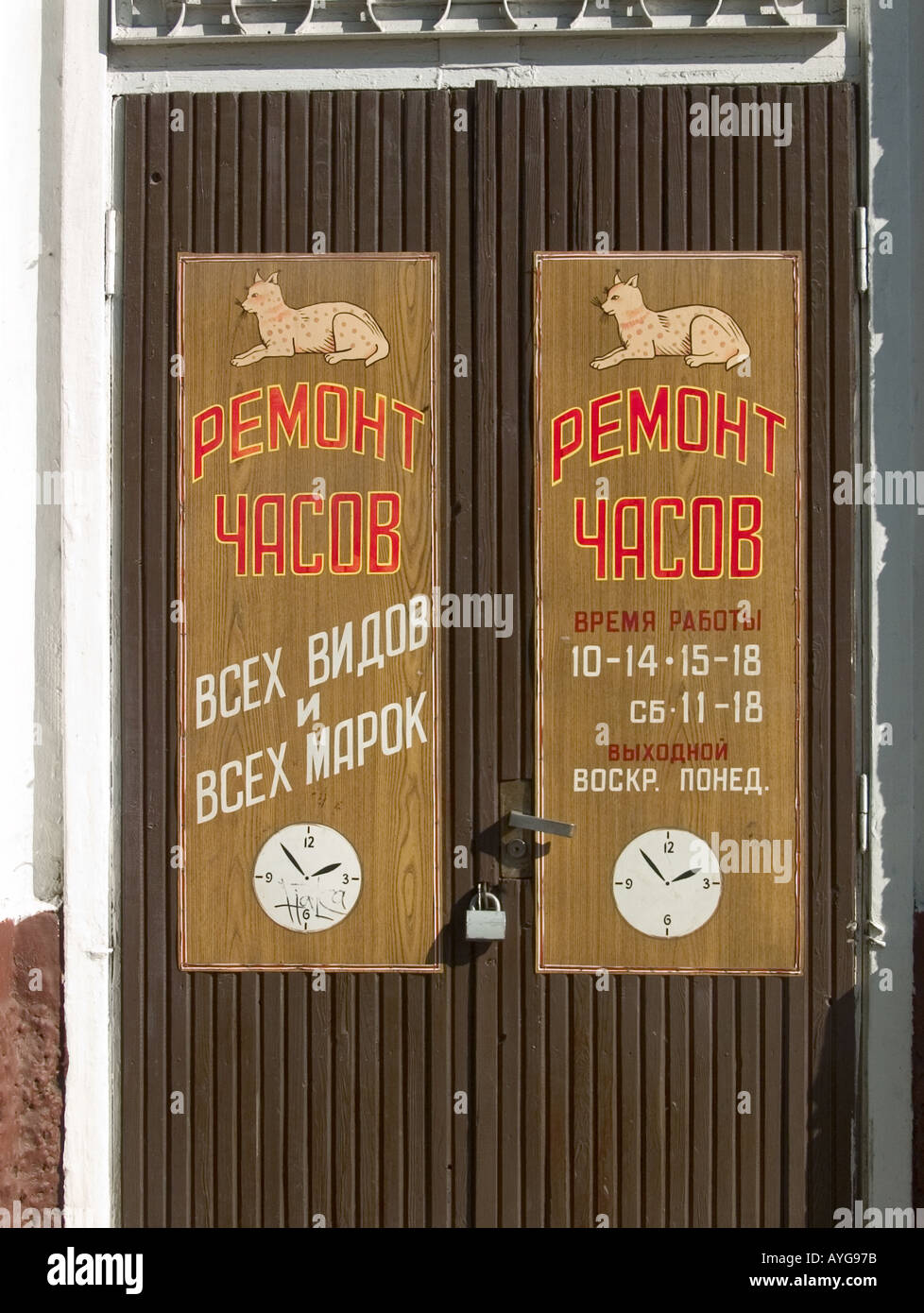 Locked and padlocked wooden doors with lynx caricatures painted on each door plus painted black and white clocks at watch repair shop in Gomel Belarus Stock Photo