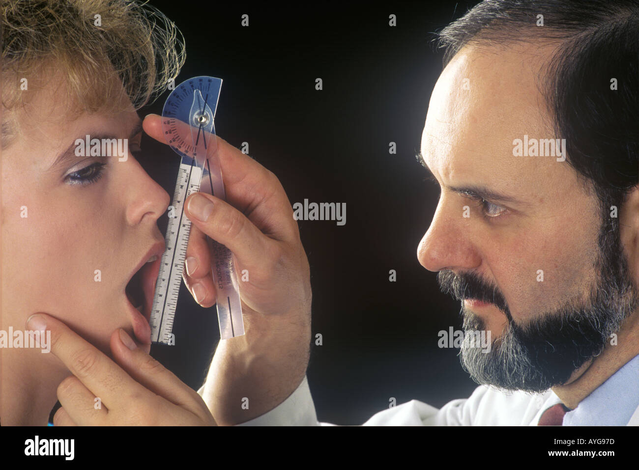 Physical therapist examines patient for TMJ Temporo Mandibular Joint Dysfunction Stock Photo