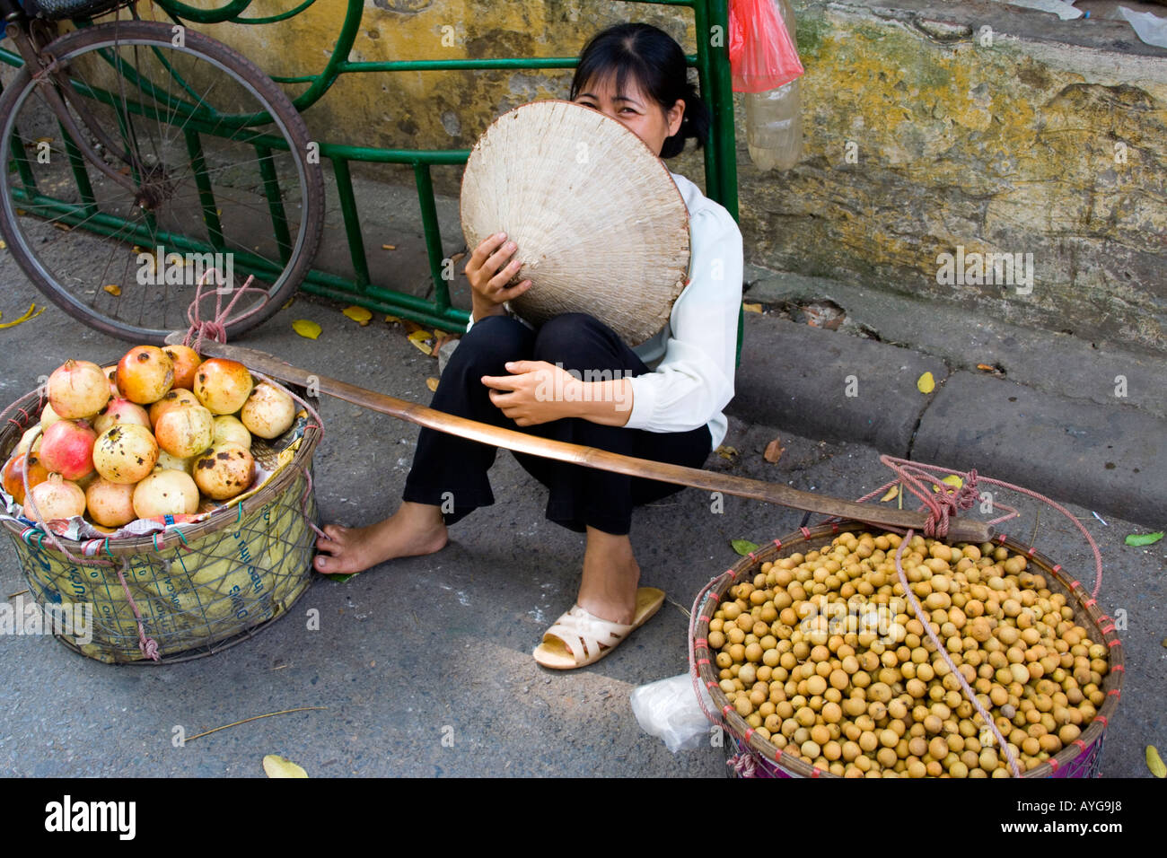 Woman Wearing a Traditional Vietnamese Rice Hat Sells Fresh Longan and pomegranates Hanoi Vietnam Stock Photo