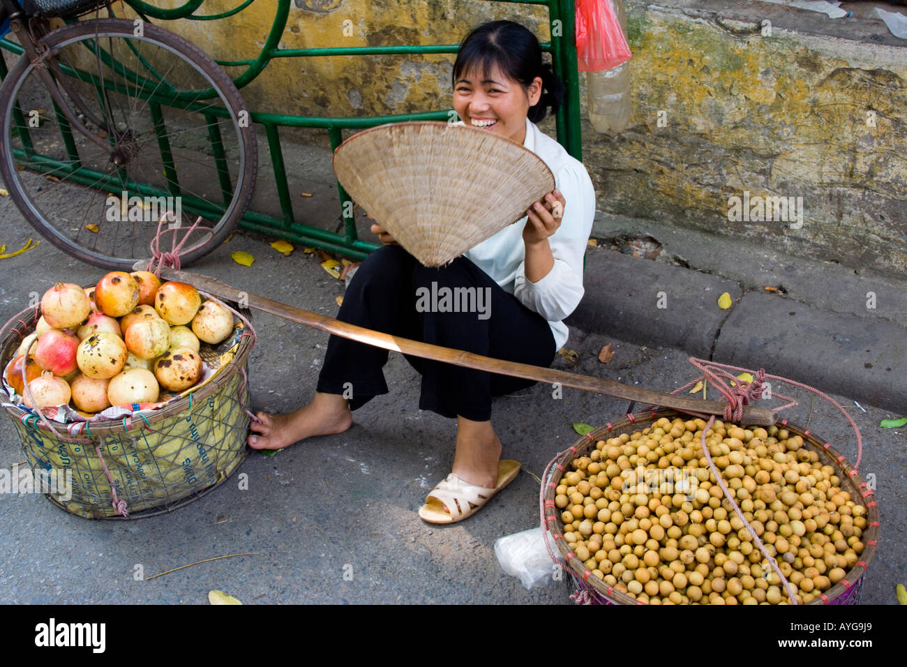 Woman Wearing a Traditional Vietnamese Rice Hat Sells Fresh Longan and pomegranates Hanoi Vietnam Stock Photo