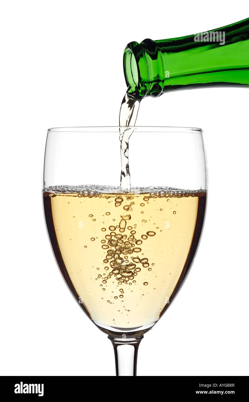 White Wine Pouring Into a Glass Against a White Background Close Up Stock Photo