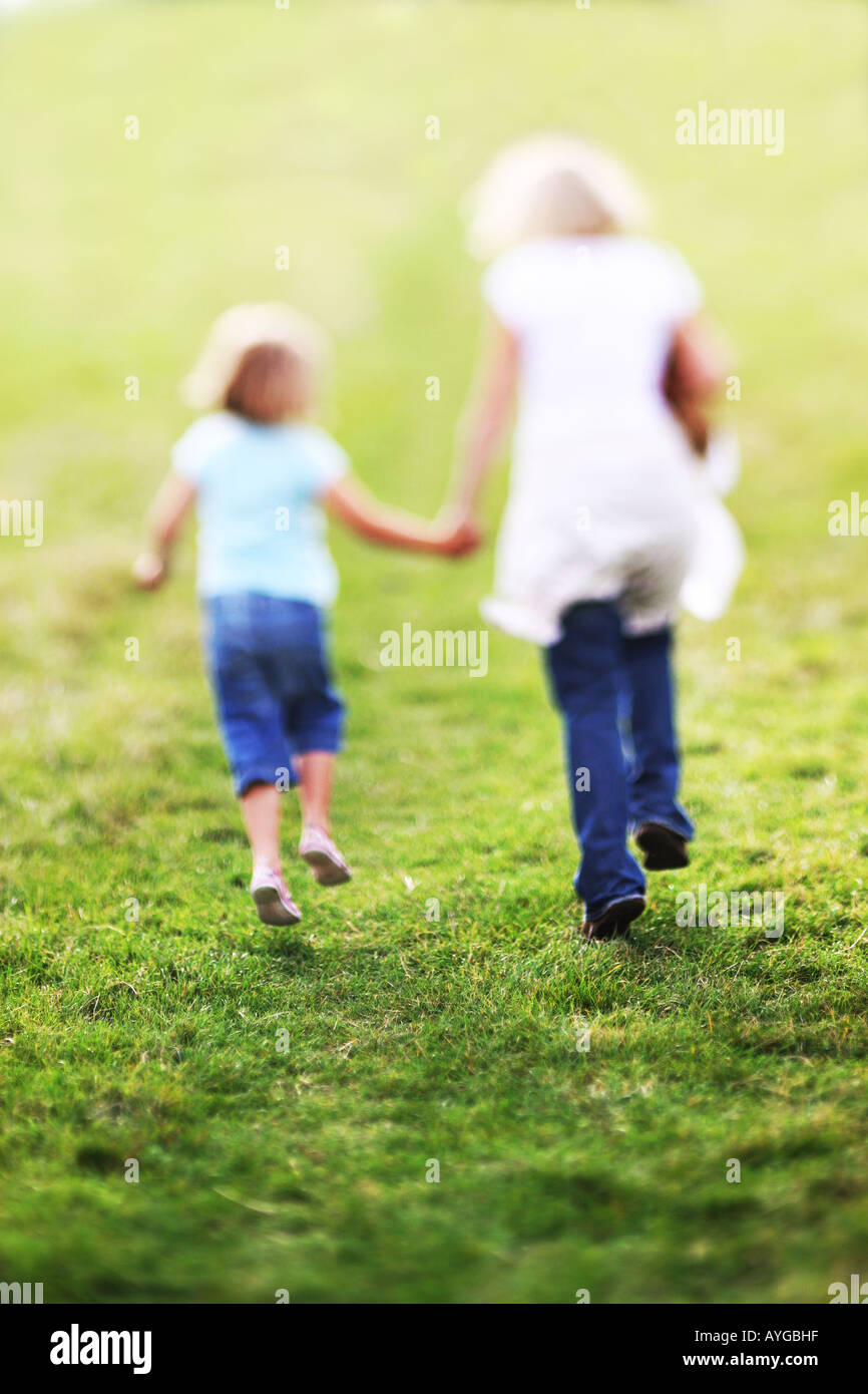 mother and daughter skipping while holding hands Stock Photo Alamy