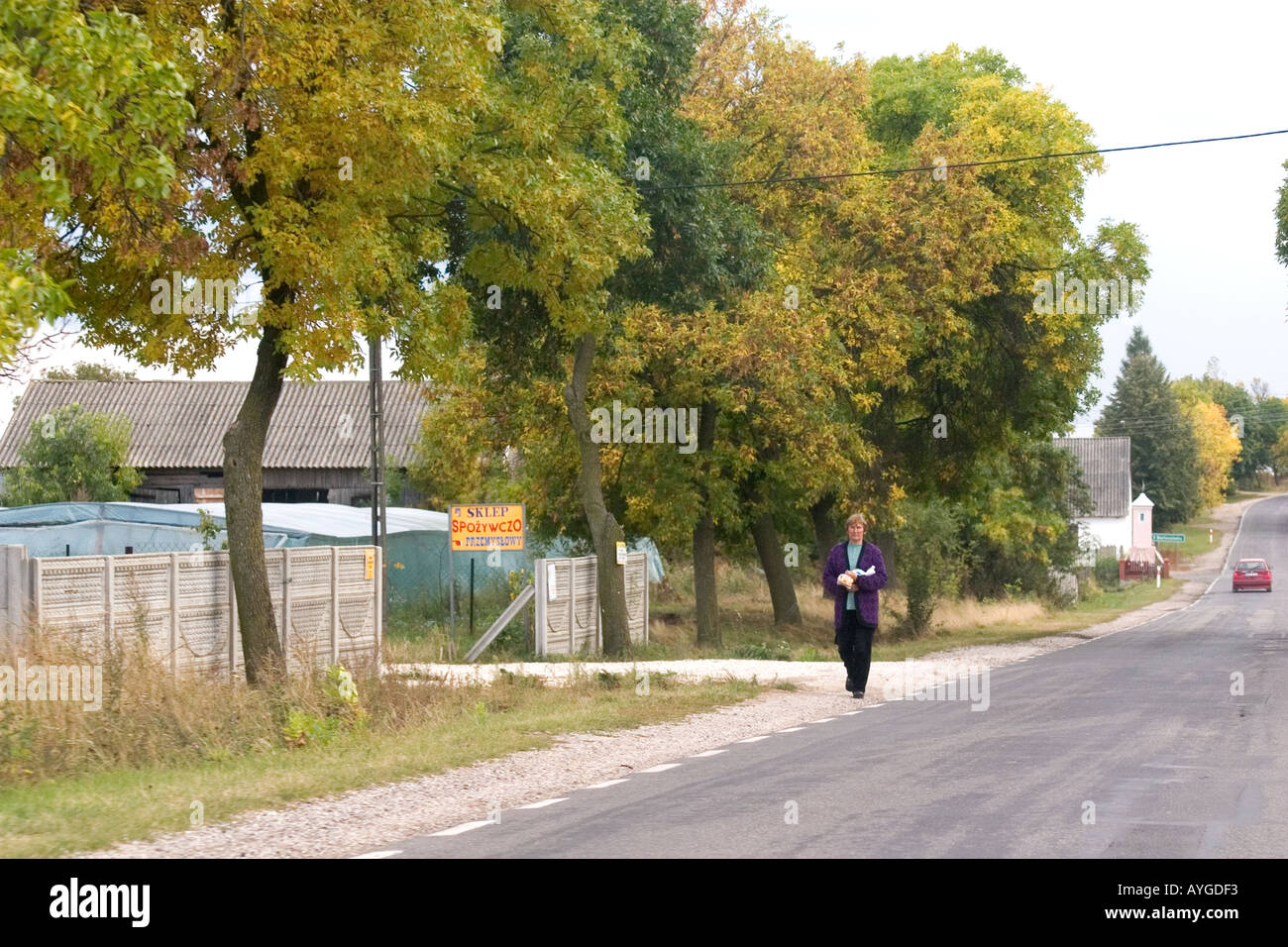 Woman walking along the road. Rawa Mazowiecka Poland Stock Photo