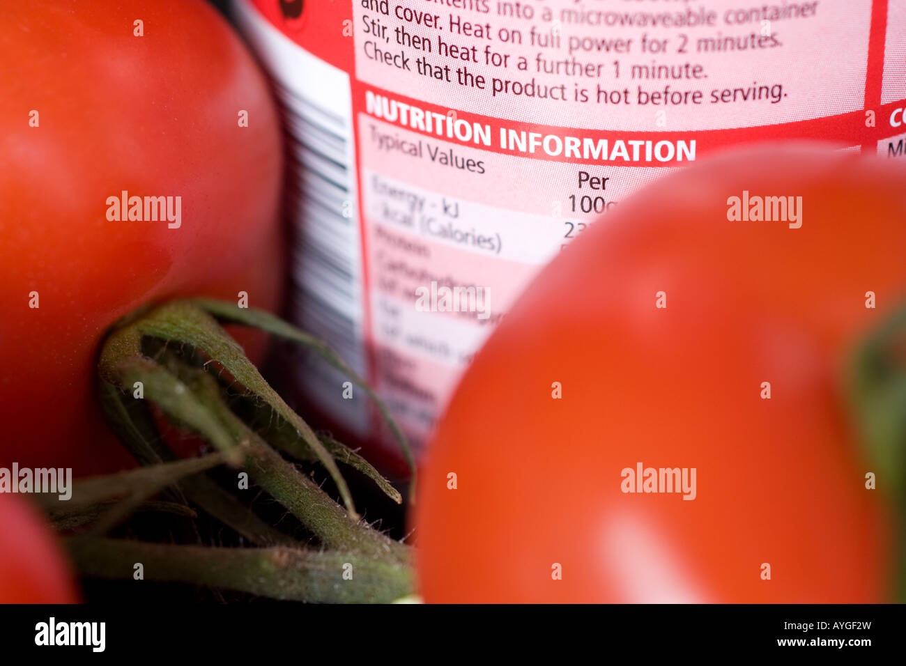 food ingredients labels labeling on can of tomato soup with fresh tomatoes in background displaying nutrional information Stock Photo