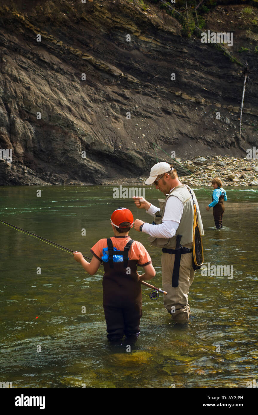 Father and sons fly fishing in mountain river Stock Photo