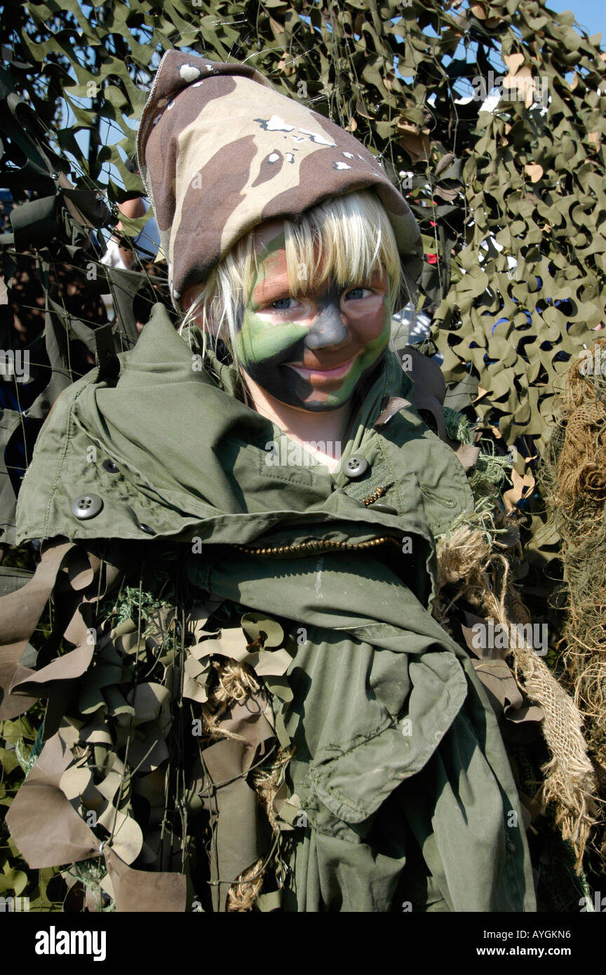 Child is dressed in camouflage clothing while attending an Army demonstration Stock Photo