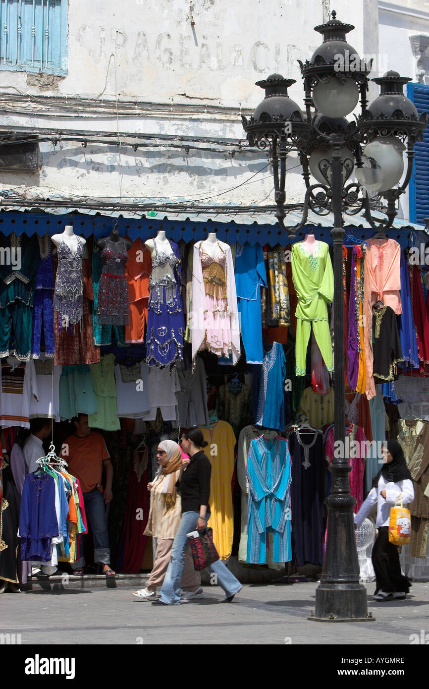 Women walk past clothing shop Place del la Victoire the Medina Tunis Tunisia Stock Photo