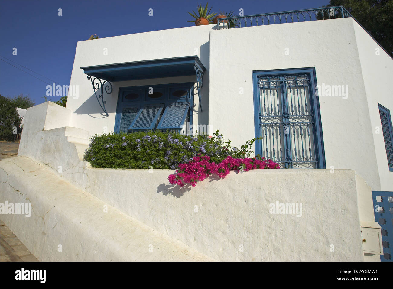 Whitewashed home with blue trim and lilac bougainvillea Sidi Bou Said village Tunisia Stock Photo