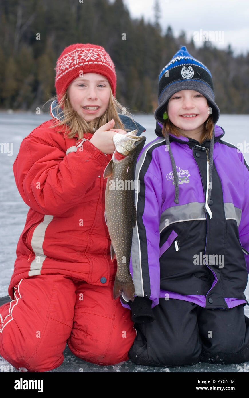 two girls ice fishing and holding a trout Stock Photo - Alamy