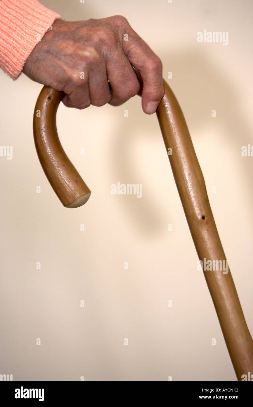 Elderly womans arthritic hand on walking stick retirement