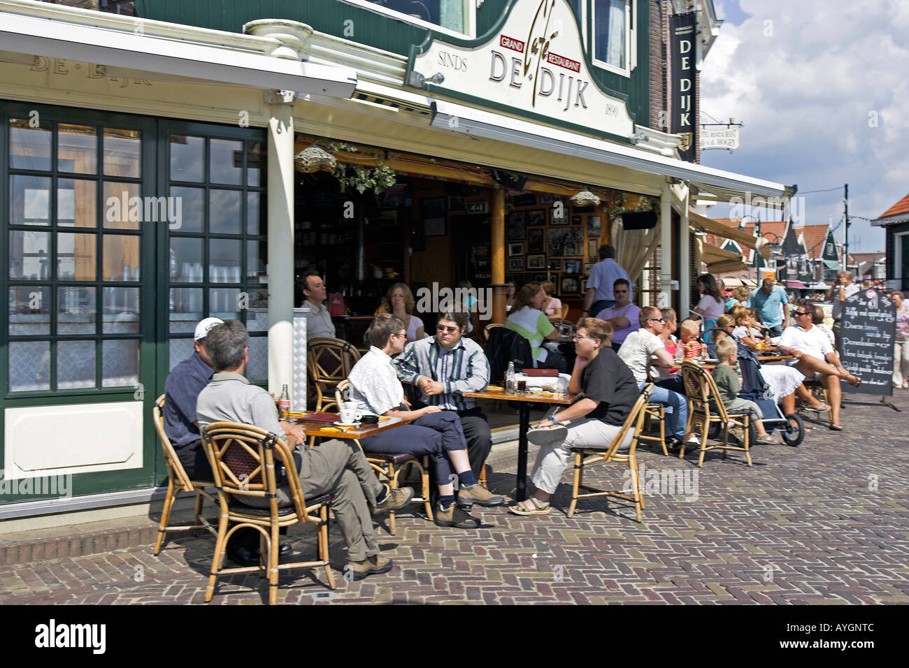 Visitors sit in sunshine outside restaurant Volendam fishing village The Netherlands Stock Photo