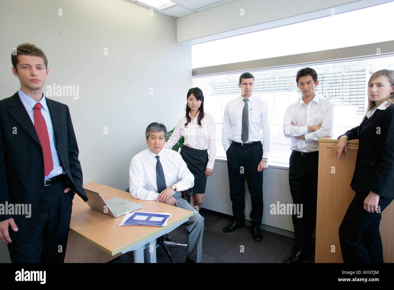 Portrait of group of business people standing in office Stock Photo - Alamy