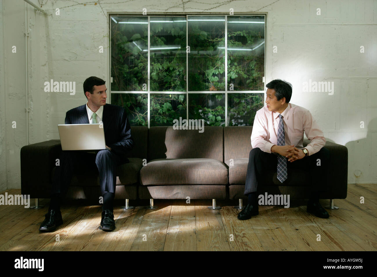 Two businessmen in lobby Stock Photo - Alamy