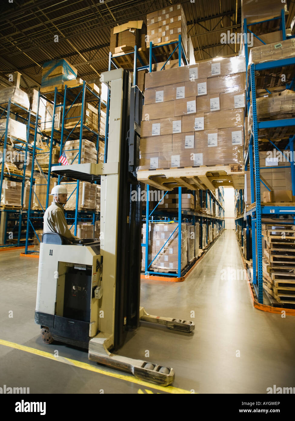 Warehouse worker driving forklift Stock Photo