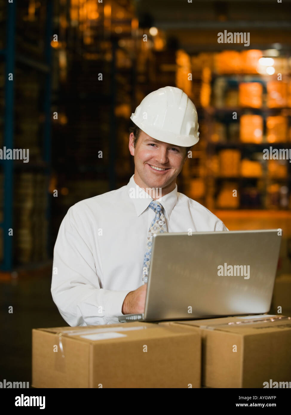 Businessman wearing hard hat in warehouse Stock Photo Alamy