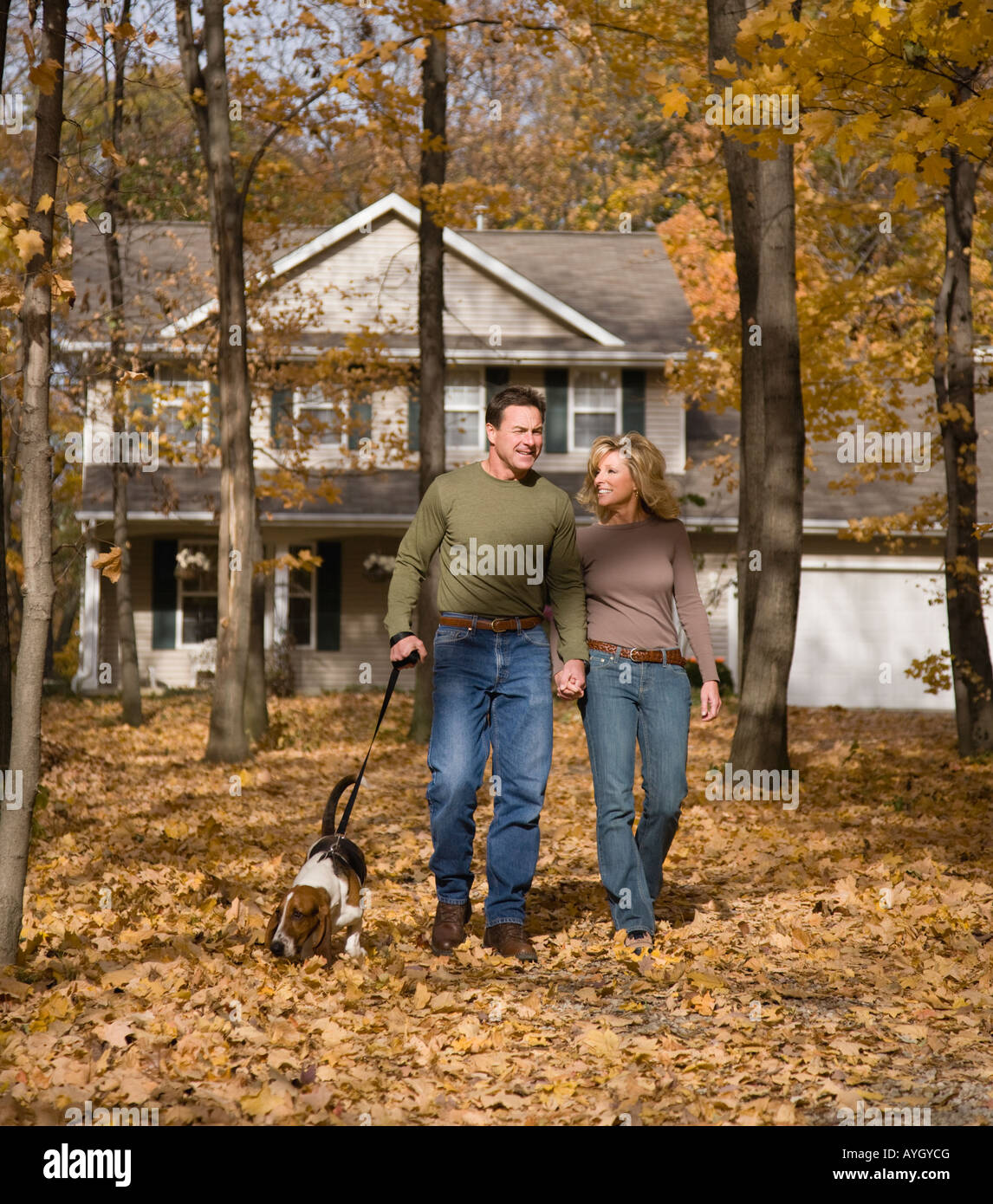 Couple walking dog in woods Stock Photo - Alamy