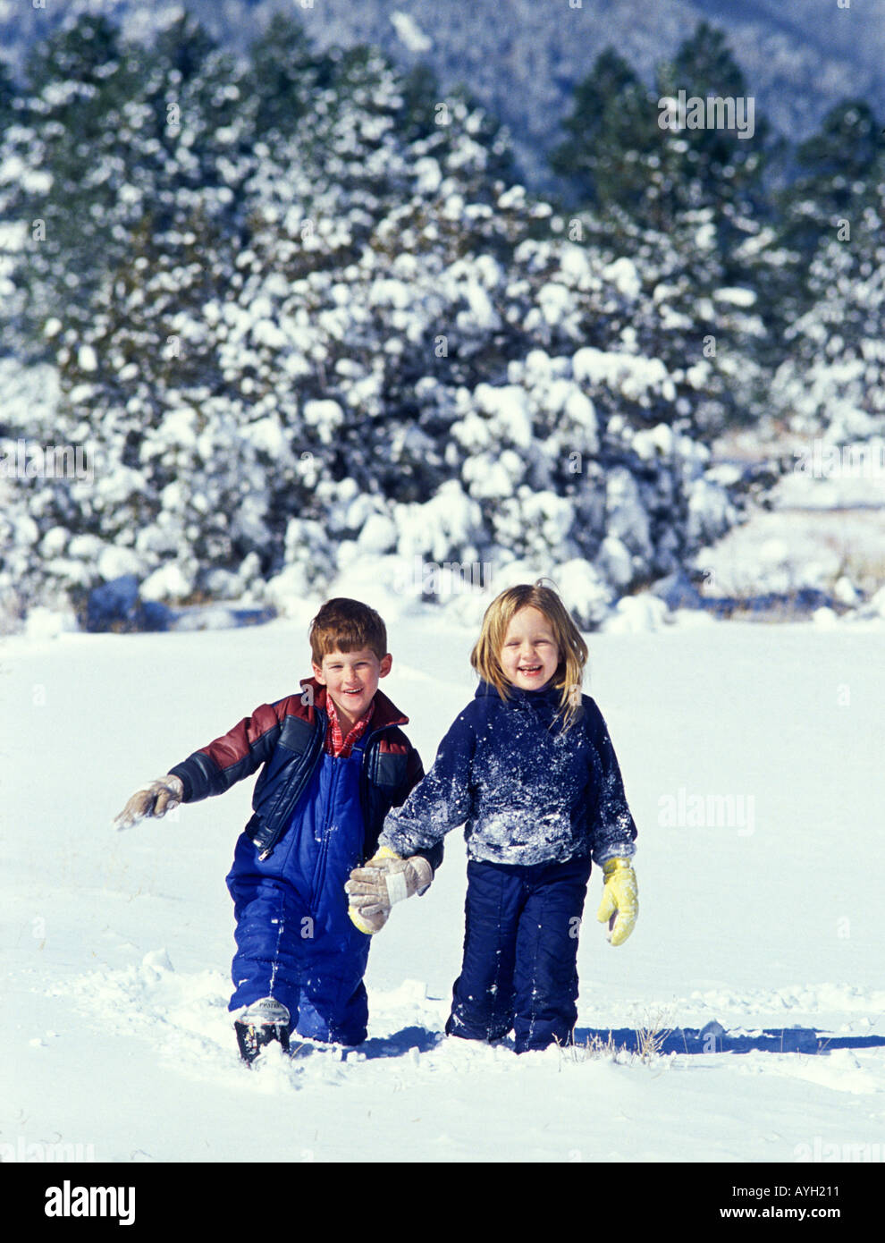 Boy and girl play in new snow after a storm MR Stock Photo
