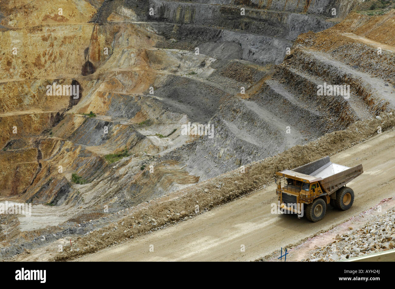 A giant dump truck descends a ramp into the open cast Martha gold mine in Waihi New Zealand Stock Photo