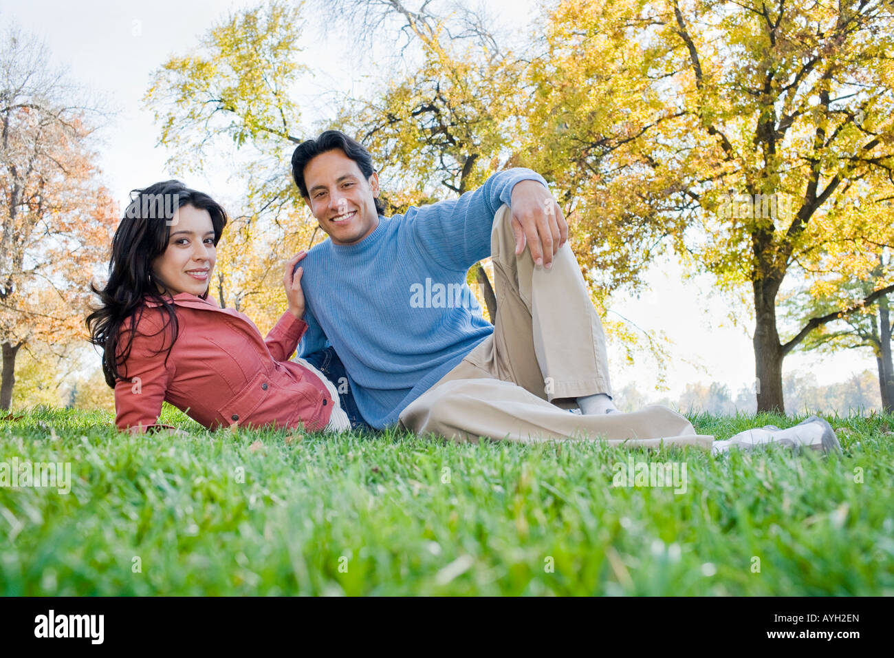 Couple sitting in grass Stock Photo - Alamy