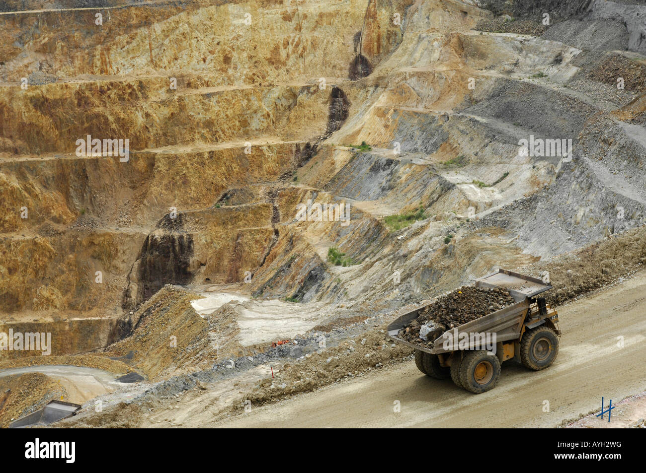 A giant dump truck ascends a ramp at the open cast Martha gold mine in Waihi New Zealand Stock Photo