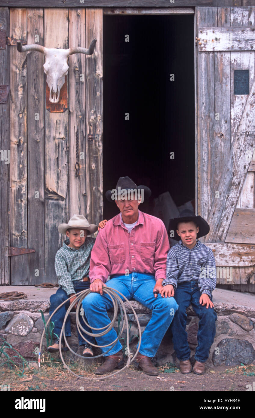 Cowboy Sam Udall teaching his grandsons Derek and Dillon the ropes of ranching MR Stock Photo
