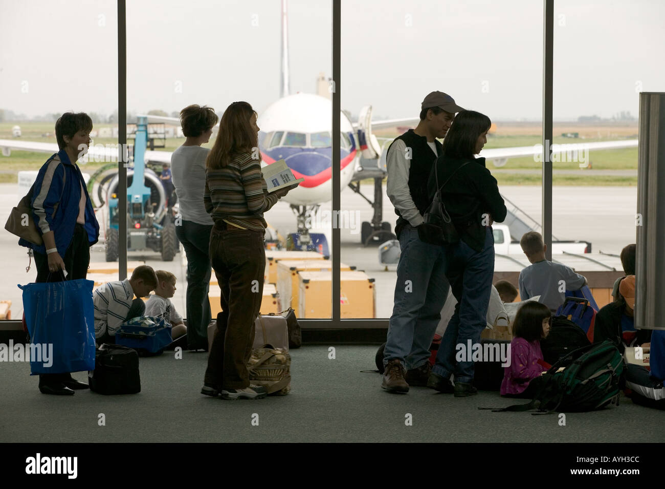 Airport travel delays. Travelers wait to board an airliner. Stock Photo