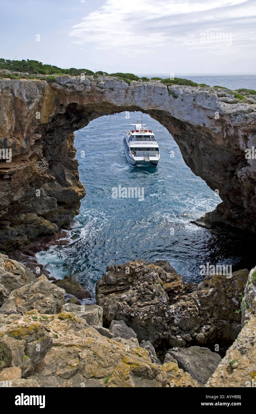 Tourist boat and natural stone arch.Near Porto Cristo.Mallorca Island.Spain Stock Photo