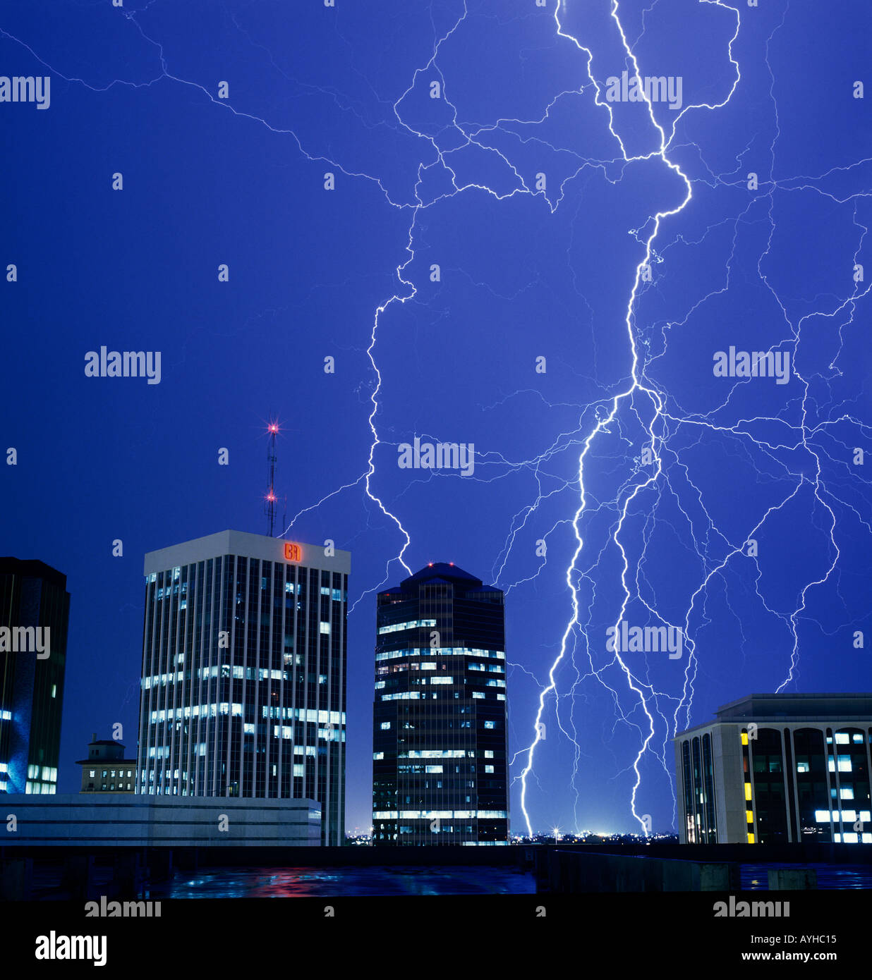 Multiple distant lightning bolts strike during a summer monsoon storm over a downtown cityscape of Tucson Arizona United States Stock Photo