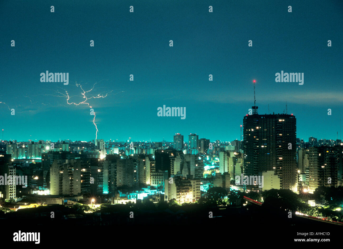 A bolt of lightning strikes over the cityscape of Buenos Aires, Argentina from an aqua blue sky. Stock Photo